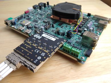 Close-up of a circuit board with connected quad SFP28 transceiver module.