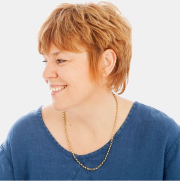 a smiling woman with a blue sweater.