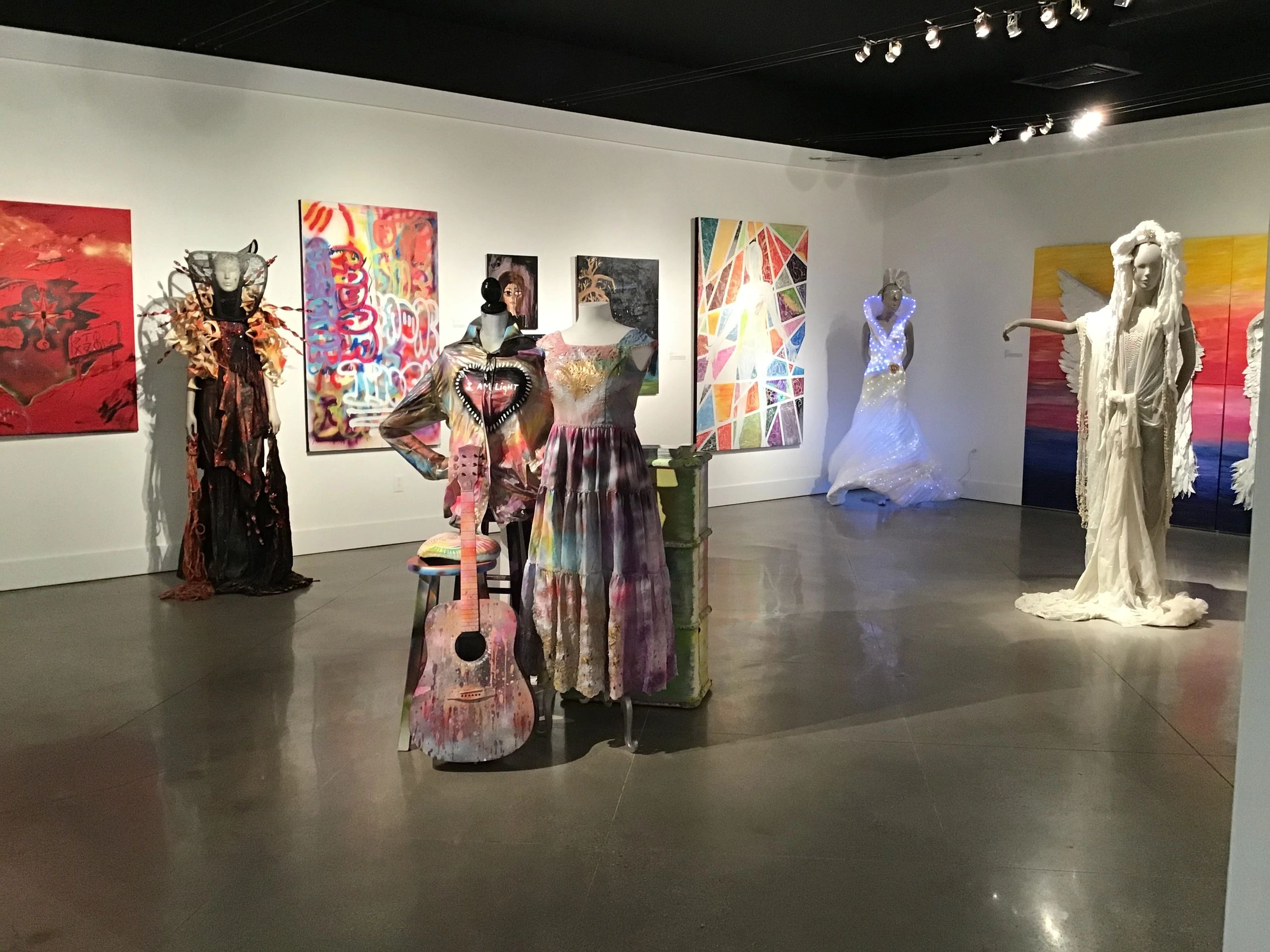 Art gallery with avant-garde mannequins and paintings.