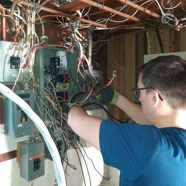 Doctor Electric team member servicing an indoor electrical panel