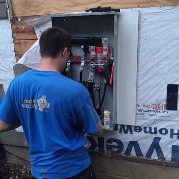 Doctor Electric team member servicing outdoor electrical panel