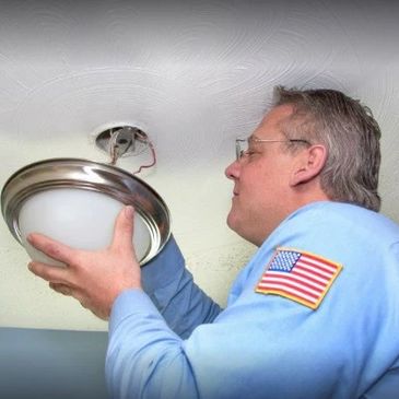 Doctor Electric team member installing light fixture