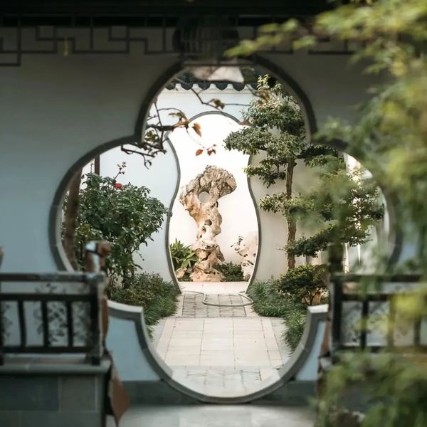 A serene garden view through a traditional Chinese moon gate.