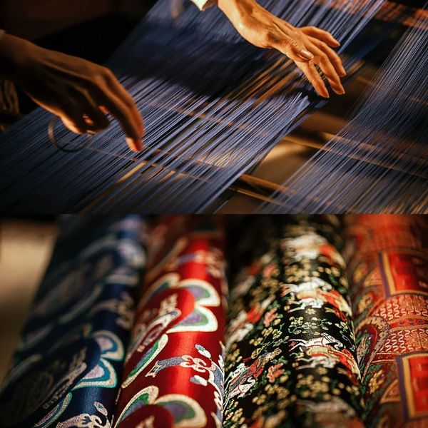 Hands weaving blue threads above vibrant patterned fabrics.