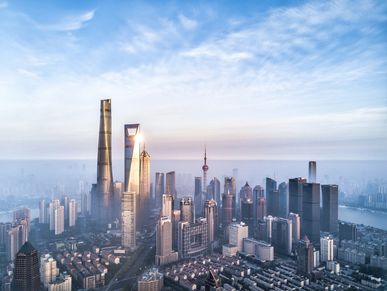 A majestic city skyline with towering skyscrapers under a partly cloudy sky.