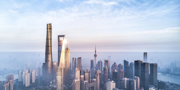 A majestic city skyline with towering skyscrapers under a partly cloudy sky.
