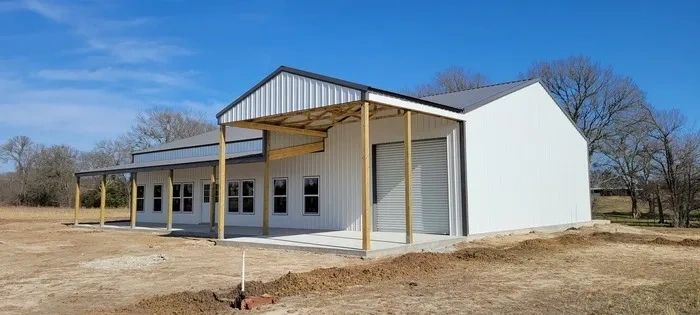 Barndominium shell that is black and white colors with concrete.