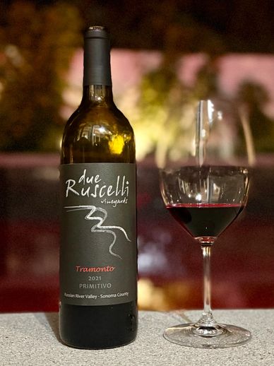 Bottle of Due Ruscelli Tramonto 2021 wine with a glass of red wine.