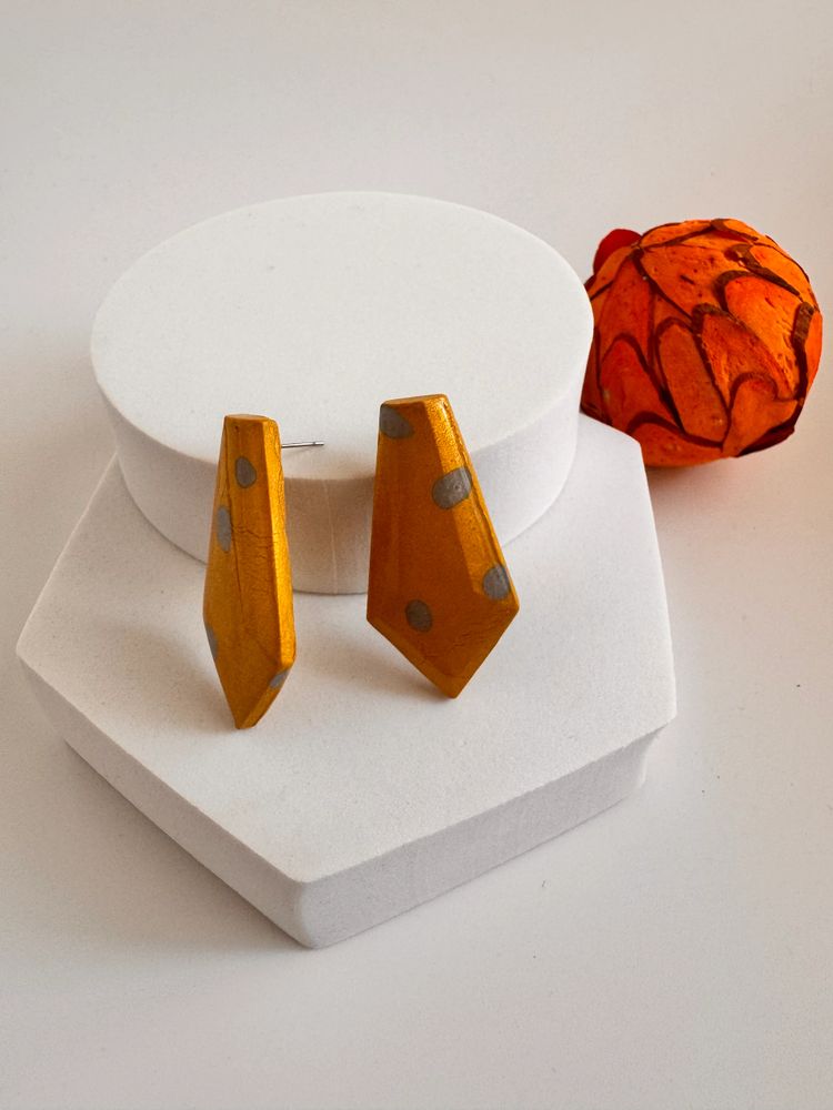 Orange and grey earring on white display