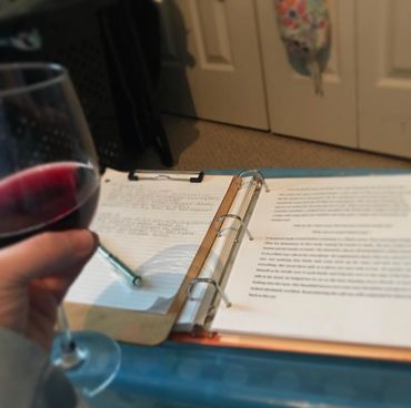 Erin has a relaxing glass of wine as she writes.