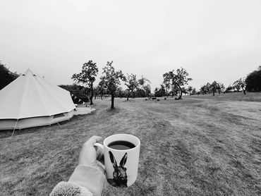 luxury glamping at plum tree glamping guest holding a coffee cup