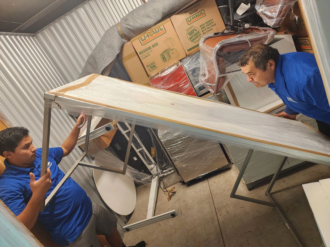 Team of professionals working on architectural blueprints with a yellow hard hat nearby.