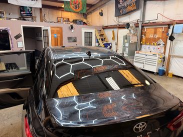 Black Toyota car inside a garage.