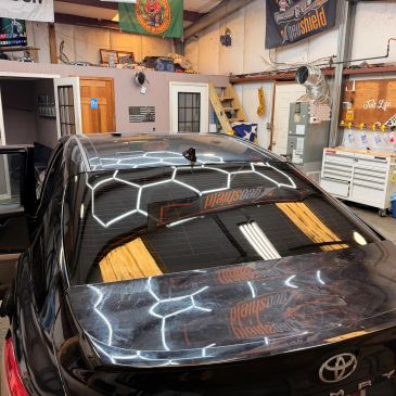 Black Toyota car inside a garage.