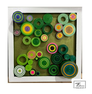 Colorful concentric circles art piece in a white frame.