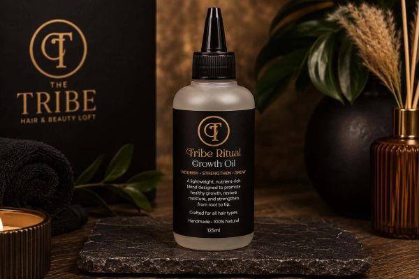 Elegant bottle of Tribe Ritual Growth Oil on stone slate.