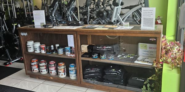 Gym reception area with supplements and fitness apparel display.