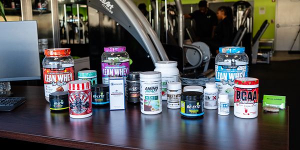 Various fitness supplements displayed on a gym counter.