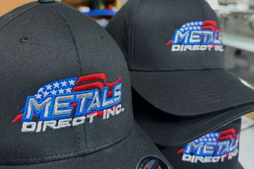 Black caps with embroidered 'Metals Direct Inc.' logo featuring an American flag.