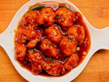 Chicken Manchurian: Crispy chicken in tangy sauce with soy, garlic, ginger & green onions. A favorit