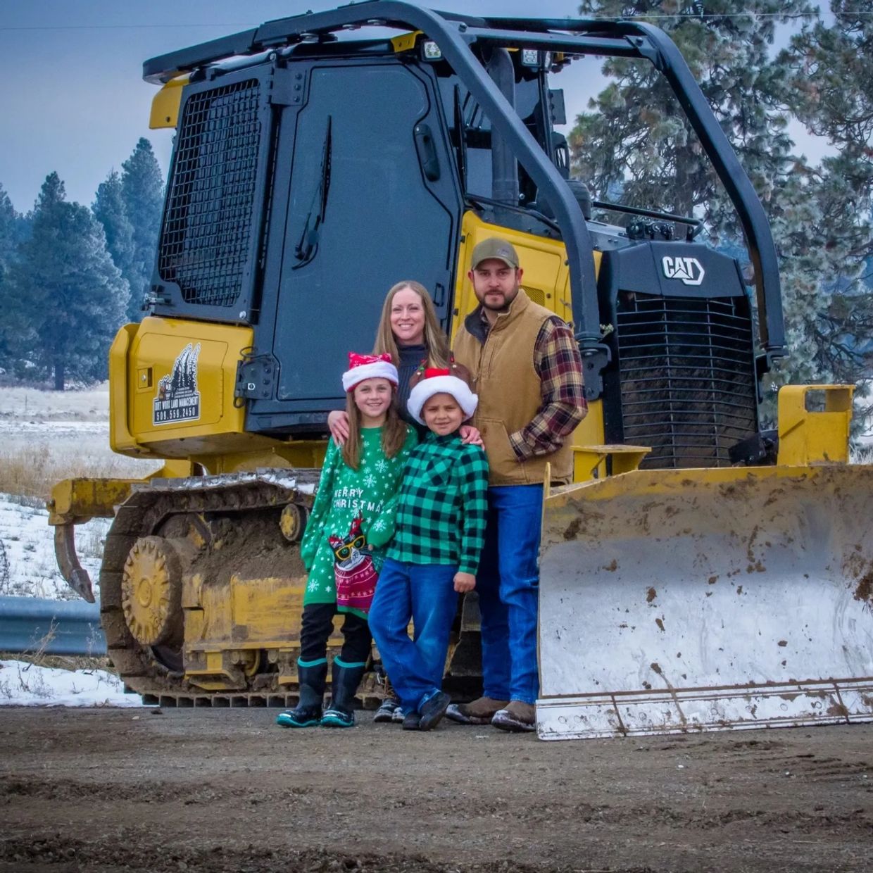 a couple with their two kids near an excavator