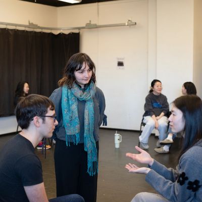 A group of people engaged in conversation in a casual indoor setting.