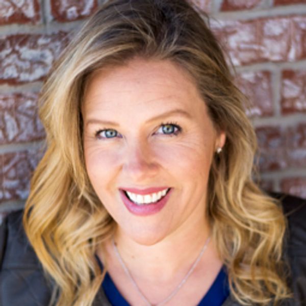 Smiling blonde woman with blue eyes.