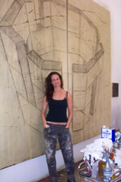 Image of Artist Amber Brookman standing in front of one of her large geometric rendering