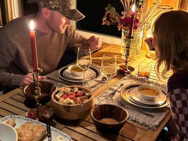 A couple sitting eating butternut squash soup at a dining table
