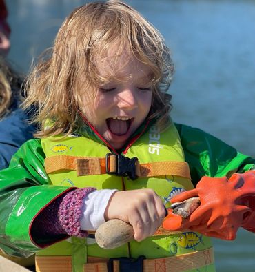 A young child's first time shucking oysters in Maine