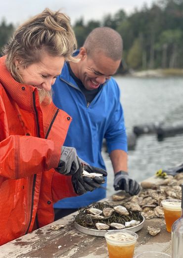 A couple learning how to shuck oysters in Phippsburg, ME