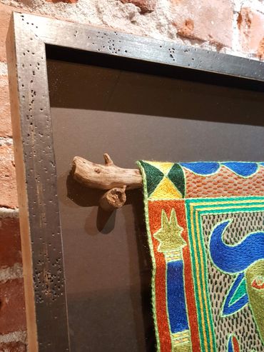 Hand embroidered textile framed with archival mounting and custom matting.