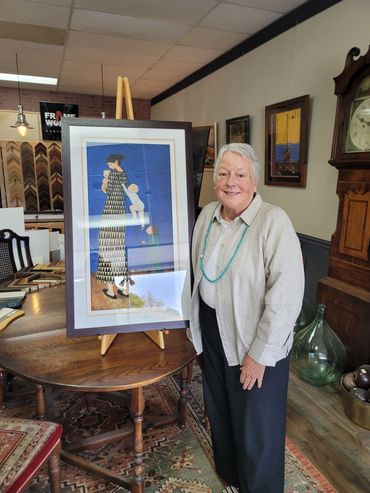 customer standing with custom framed artwork