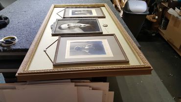 Picture frames laid out during repair and restoration work in the framing workshop.