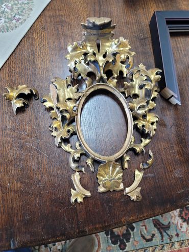 Antique ornate picture frame undergoing restoration work.