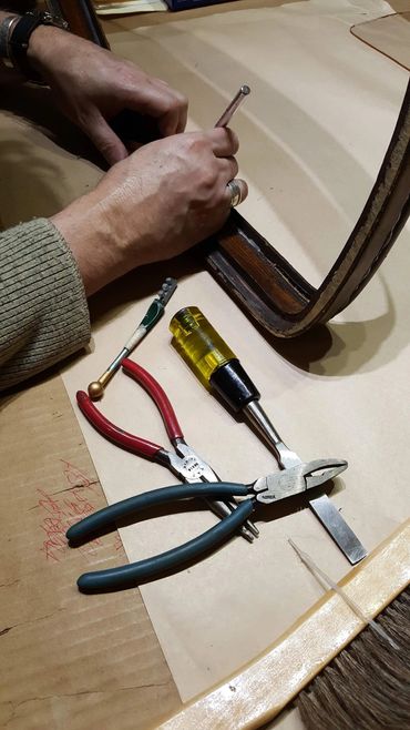 Repairing a damaged wooden frame corner with hand tools.