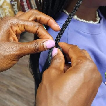 woman braiding hair using african hair braiding technique