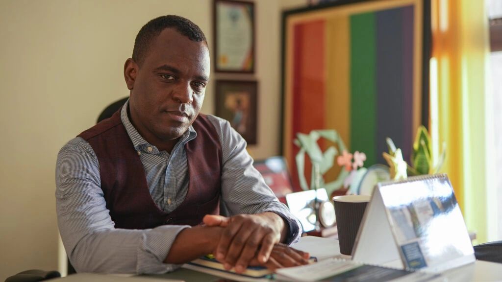 Man sitting thoughtfully at a desk.