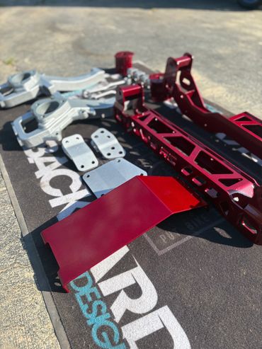 Red and silver metal parts arranged on a mat outdoors.