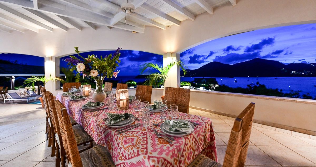 Bluff House outdoor dining table set for dinner with friends. Views towards Montserrat & Turtle Bay