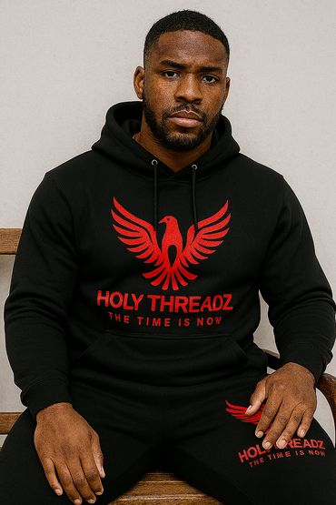 Man wearing black hoodie and pants with red phoenix logo and text.