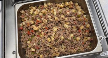 Ground beef and vegetable mix in a metal tray.
