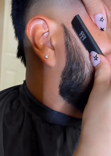 Perfil de un hombre mientras le arreglan la barba.
