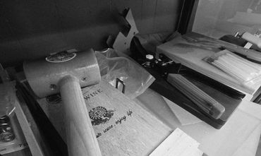 A wooden mallet resting on a wooden box with other tools around it.