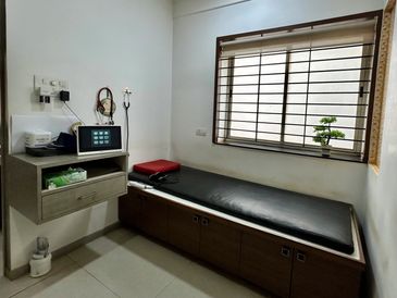 Minimalist doctor's examination room with black patient bed.