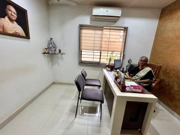 Woman sitting at desk in a modest office.