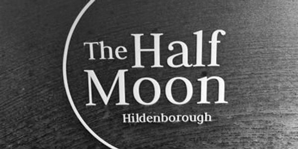 Logo of The Half Moon in Hildenborough on a dark wooden surface.