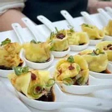 Dumplings served on white appetizer spoons
