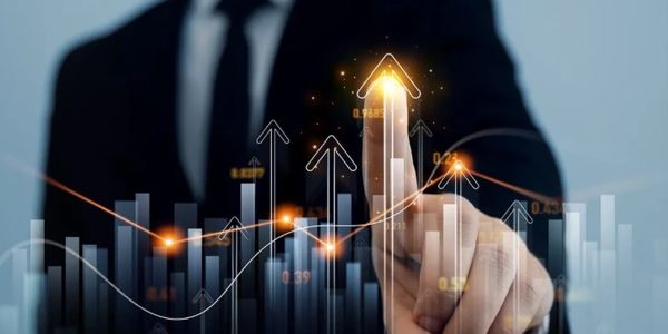 Businessman pointing at rising financial graph with glowing arrows.