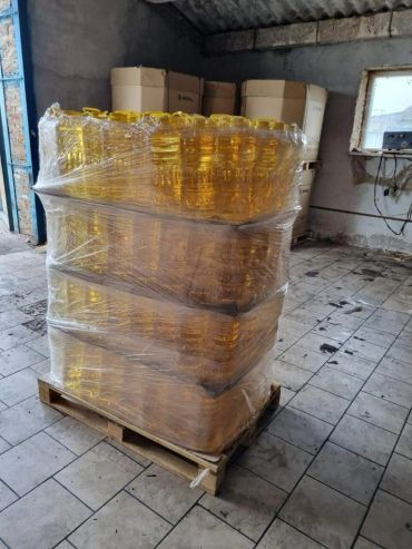 Pallet wrapped with plastic containing bottles of cooking oil.